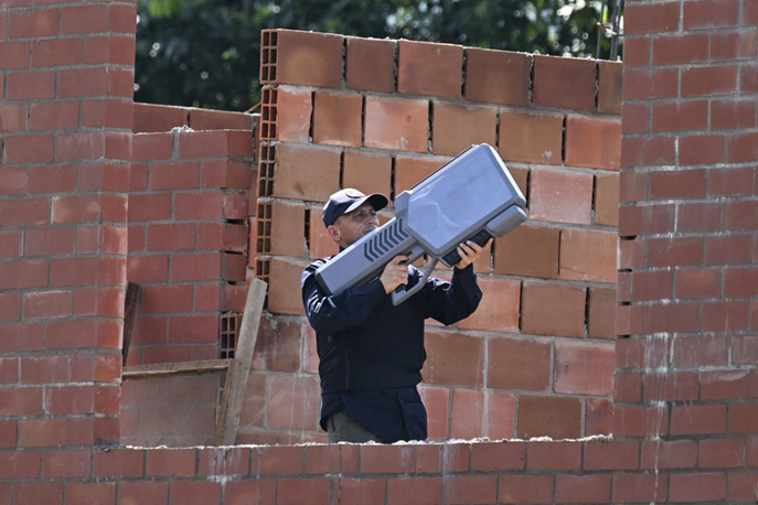 Полицейский с антидроновым ружьём стоит на страже во время открытия филиала Университета дель Валье в Суаресе