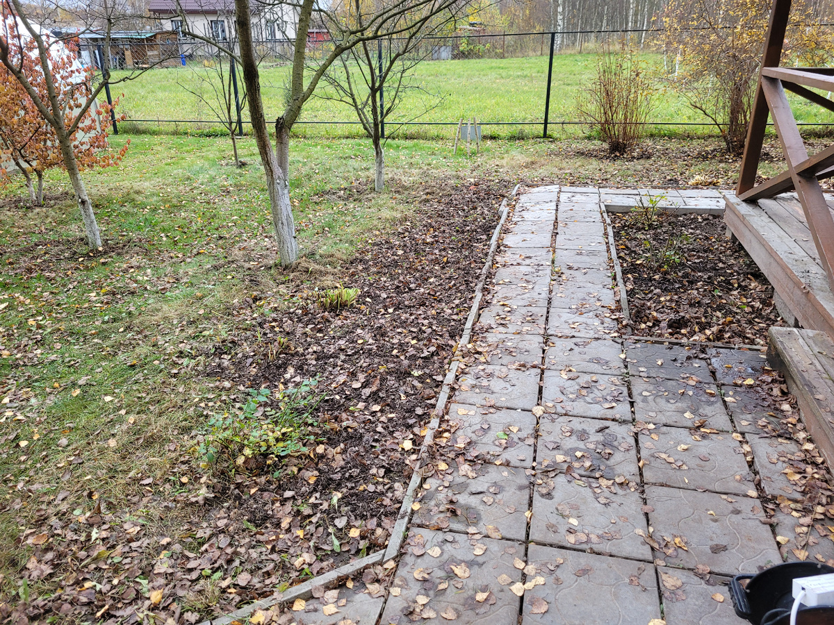 Убрала цветы перед летним домиком.