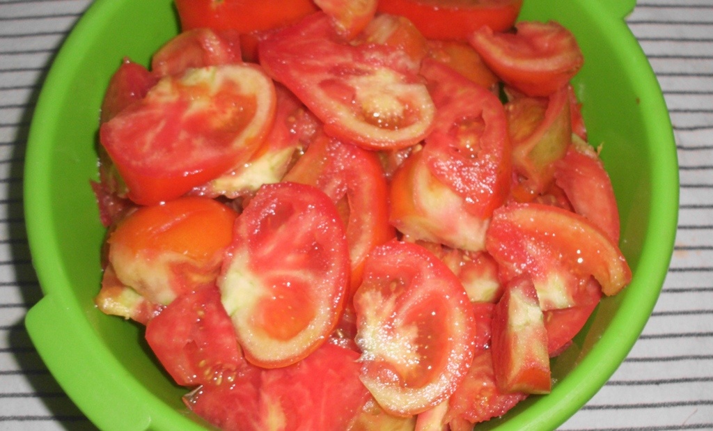 Нарезанные дольками помидоры в зеленой миске. Фото автора канала Житейская проза