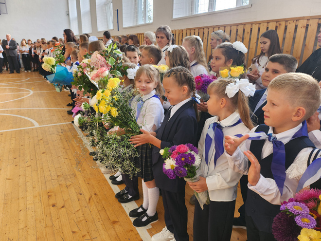 
На линейке в Троицкой школе дети выстроились в ряд, держа в руках букеты цветов для своих учителей