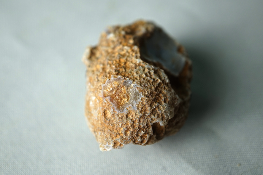 На сколе, в центре, хорошо заметен кварц, заполняющий литофизу.