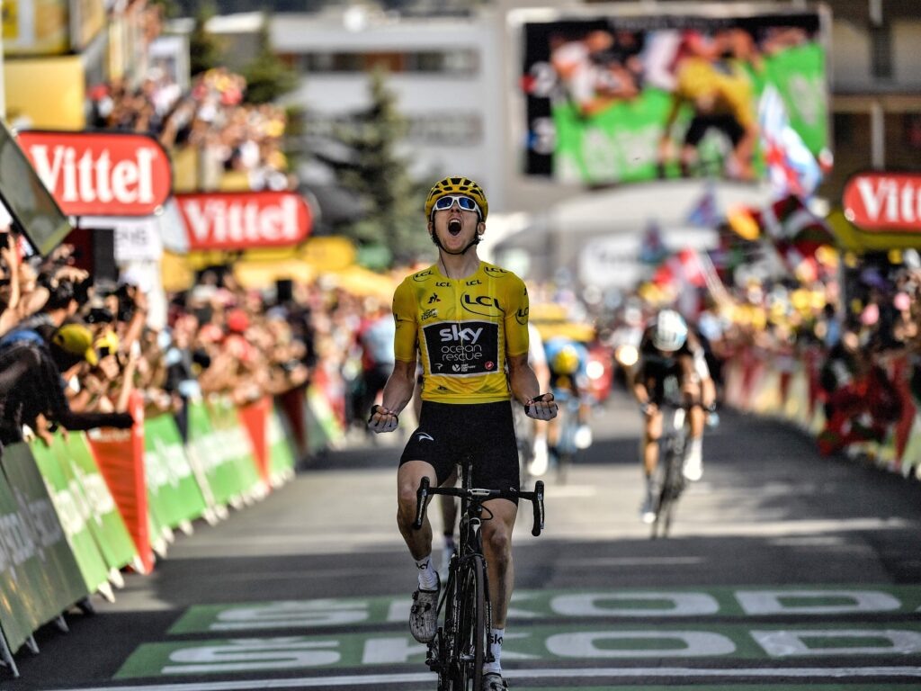 TOPSHOT — Great Britain’s Geraint Thomas, wearing the overall leader’s yellow jersey, celebrates as he crosses the finish line to win the twelfth stage of the 105th edition of the Tour de France cycling race, between Bourg-Saint-Maurice — Les Arcs and l’Alpe d’Huez, on July 19, 2018. (Photo by Marco BERTORELLO / AFP) (Photo credit should read MARCO BERTORELLO/AFP via Getty Images)  📷
