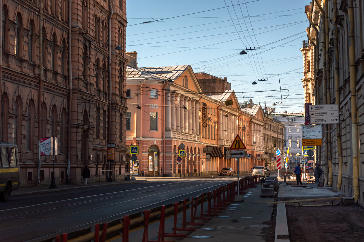 Расстояние между  домами было непривычно тесным, отчего было темно. Но из-за солнечных зайчиков, которые переотражались в стеклах, казалось, что улица светится изнутри