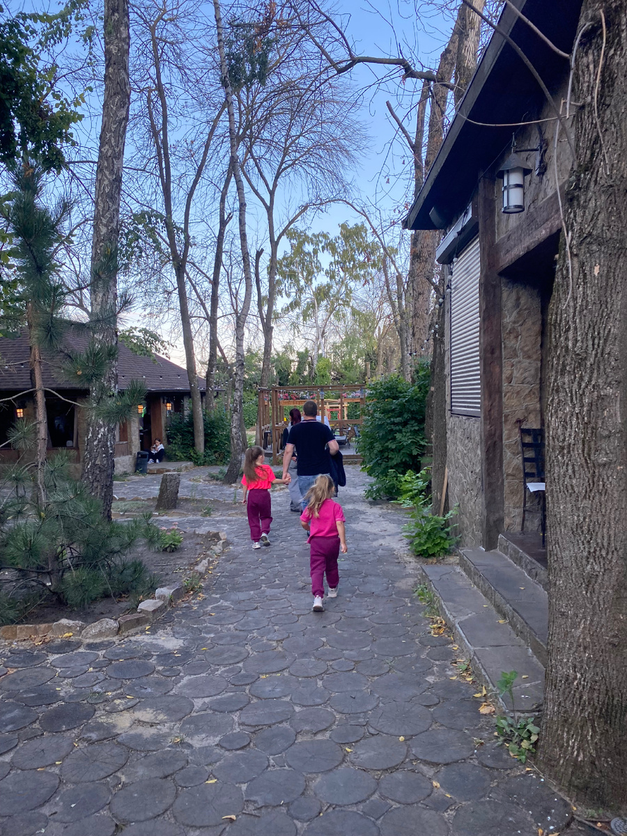 Фото автора. На летней площадке заведения. Нас ведут к забронированному месту, атмосфера «Домика Лесника».