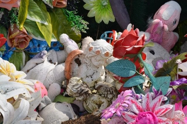    Все игрушки и венки с могилы детей убрали в сторону. Фото: АиФ/ Софья Островская