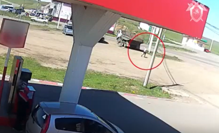 Женщина шла мимо заправки. Через мгновения перед ней притормозил белый грузовик. Фото: Скриншот видео СУ СК России по Иркутской области.