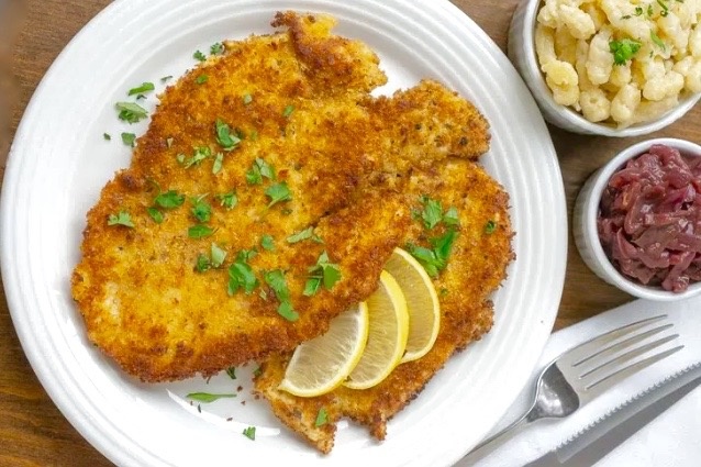 Венский шницель с лимоном, луковым соусом и картофельными клецками.