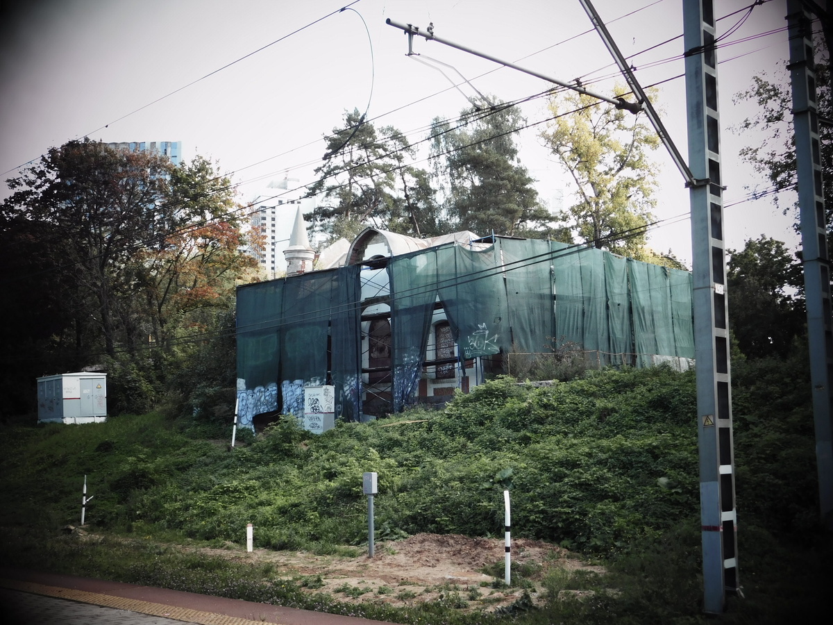 Заброшенное старинное здание, затянутое строительной сеткой