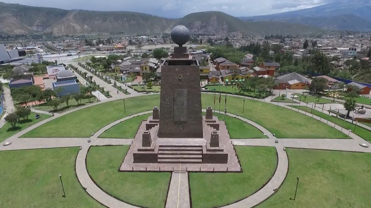 Монумент «Середина мира» в Эквадоре и проходящая через него нарисованная линия экватора