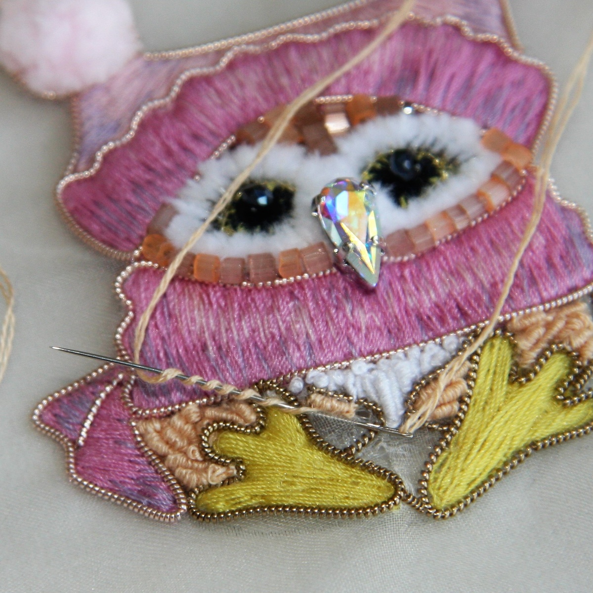 Отступили от места выхода нити на ширину стежка, проткнули ткань с лица на изнанку и вывели иглу обратно на лицо, сделали несколько оборотов нити вокруг иглы 