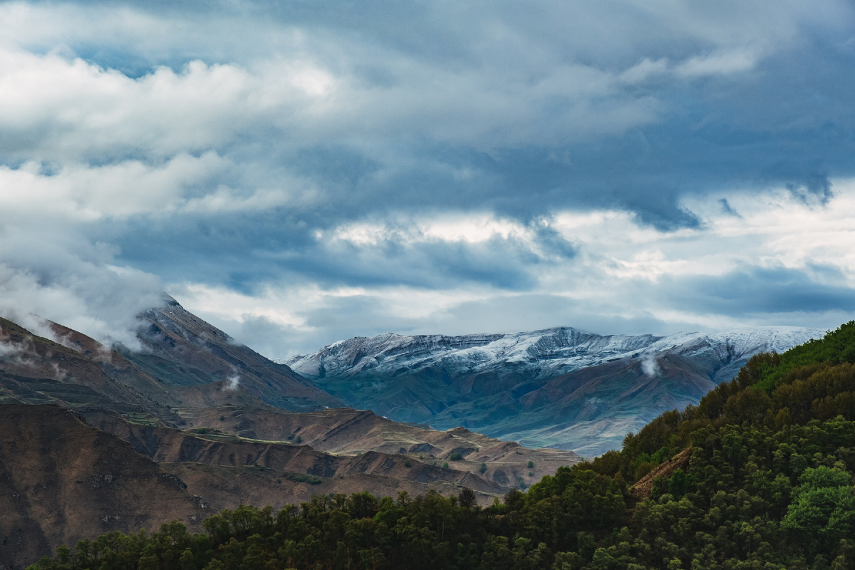 Заснеженные шапки гор вдалеке.