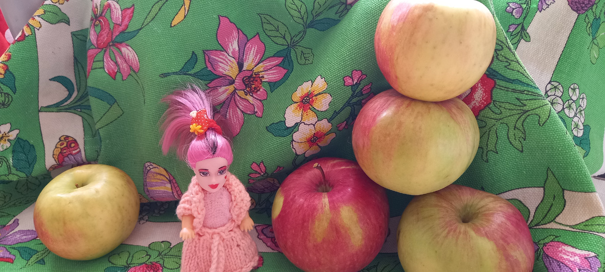 Ирэн и гора огромных яблок. Розовые цветочки в кадре  хорошо сочетаются с волосами Ирэн и её нарядом.