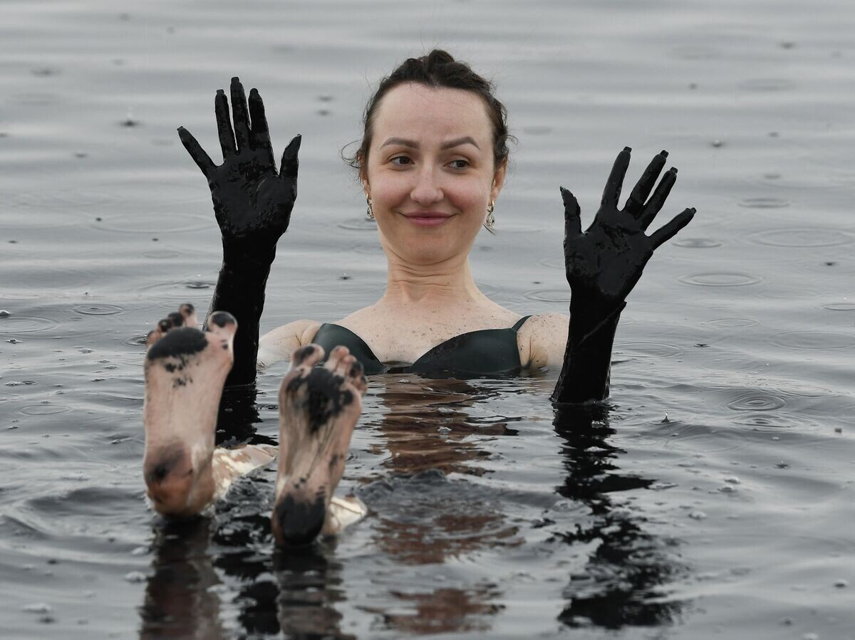    Женщина отдыхает на озере с лечебной грязью Чокрак в Крыму© РИА Новости / Константин Михальчевский