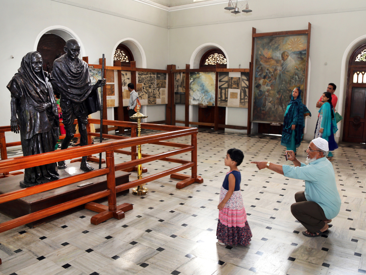 История этого дворца  тесно связана с индийским движением за свободу: с 9 августа 1942 года по 6 мая 1944 года во дворце были интернированы Махатма Ганди, его жена Кастурба Ганди и секретарь Махадев Десаи.  Слева  памятник Махатме Ганди и его жене,который осматривают посетители.