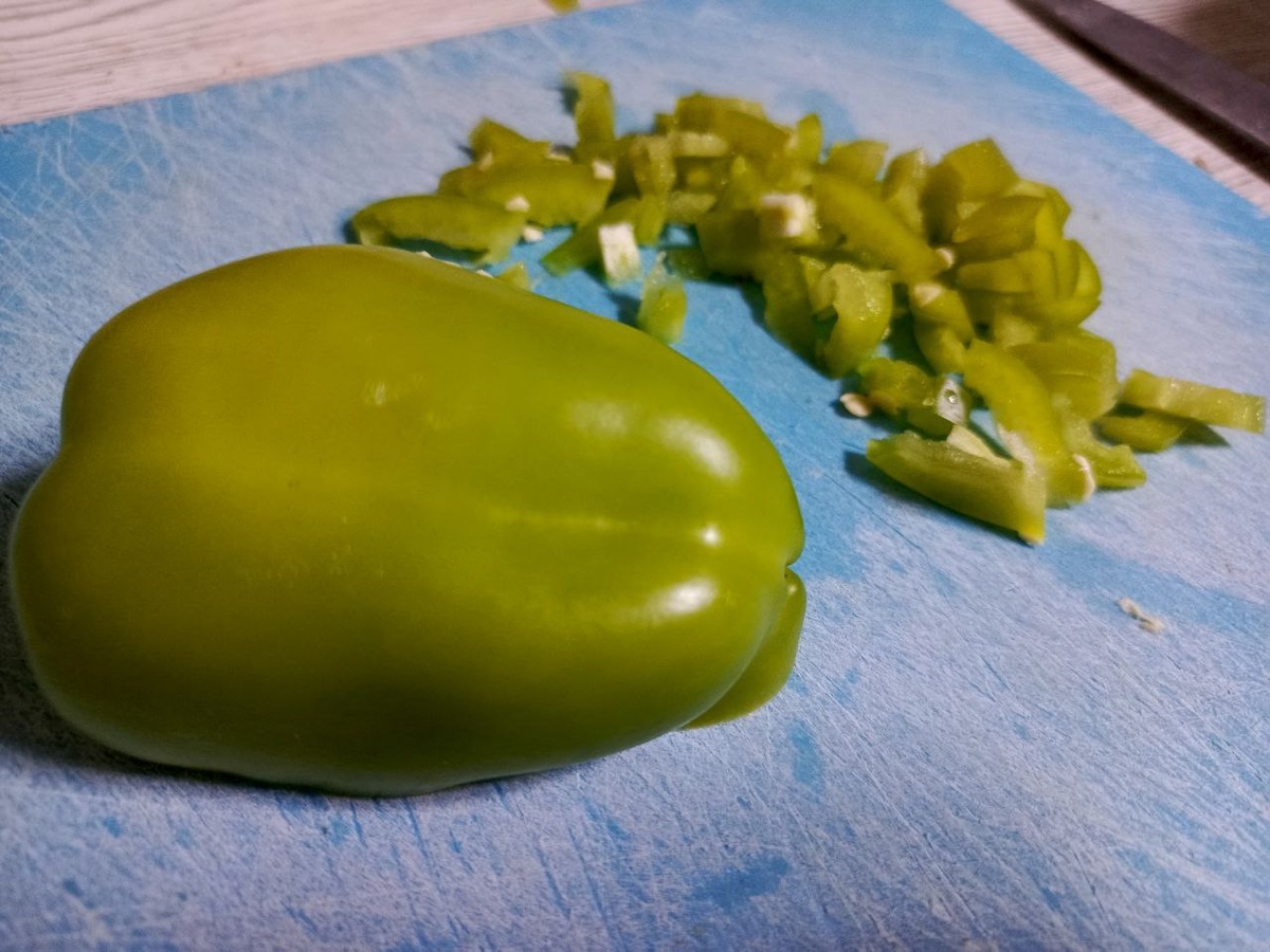 Вымойте, очистите от плодоножки болгарский перец. Измельчите его на мелкие кубики. Старайтесь не оставлять их крупными, так как важно, чтобы они пропеклись во время готовки.