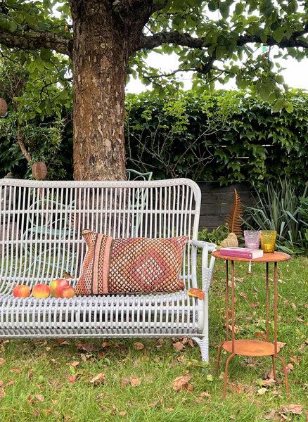 Подушка в осенних полутонах в гармонии с опавшей листвой и свечи в разноцветных стаканчиках тех же оттенков создают уютную теплую атмосферу.