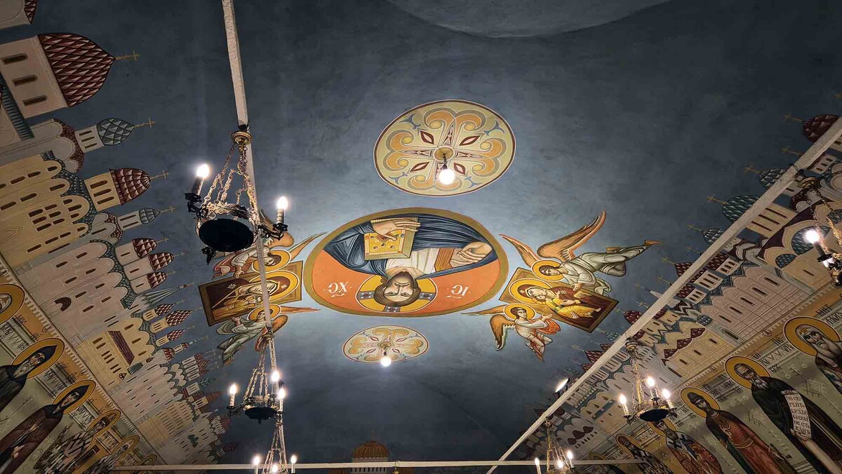 На росписях сводов — храмы, лики святых и Спаситель в голубых небесах