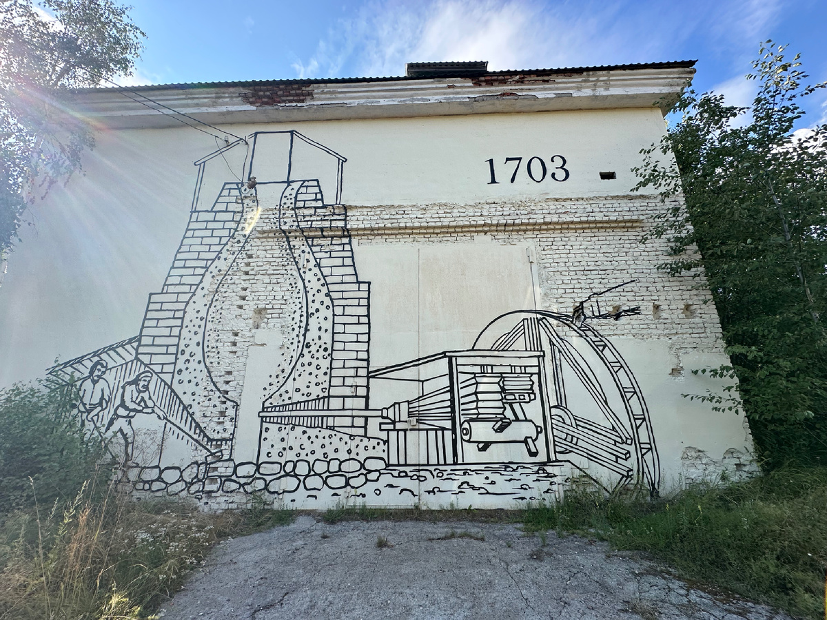 Напротив руин - здание, на стене которого, изображены работы в домнах, своего рода - схема, как всё выглядело раньше.