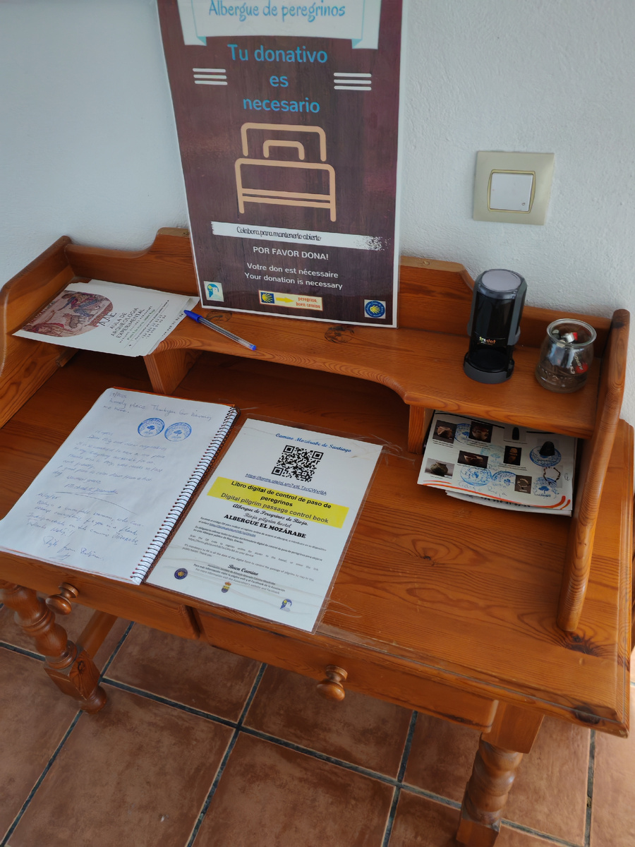 Табличка ненавязчиво напоминает, что надо оставить донативо, на столе справа qr-код для регистрации, слева журнал для отзывов