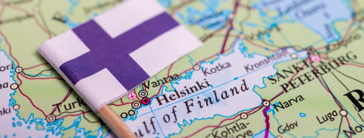    Уменьшенная копия флага Финляндии лежит на карте у наименования столицы страны — города Хельсинки. Автор фото: aileenchik / Shutterstock / FOTODOM