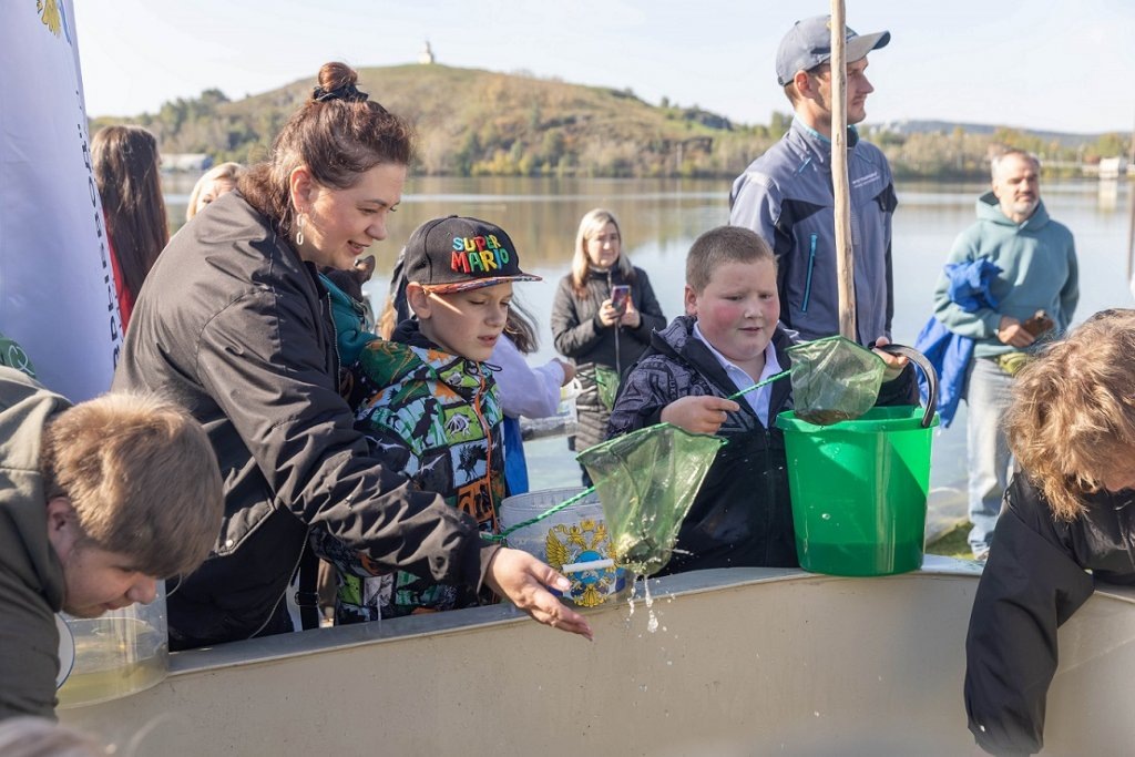    Дети выпускают рыбу в пруд в рамках проекта ЕВРАЗа