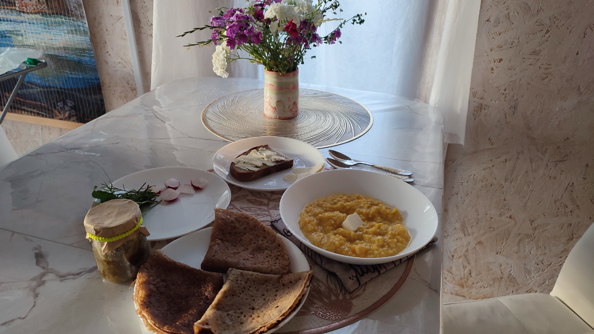 Завтрак: пшенная каша с тыквой, блины из зелёной гречки, варенье из зеленых помидоров, хлеб с маслом, сыр, редиска, укроп, руккола