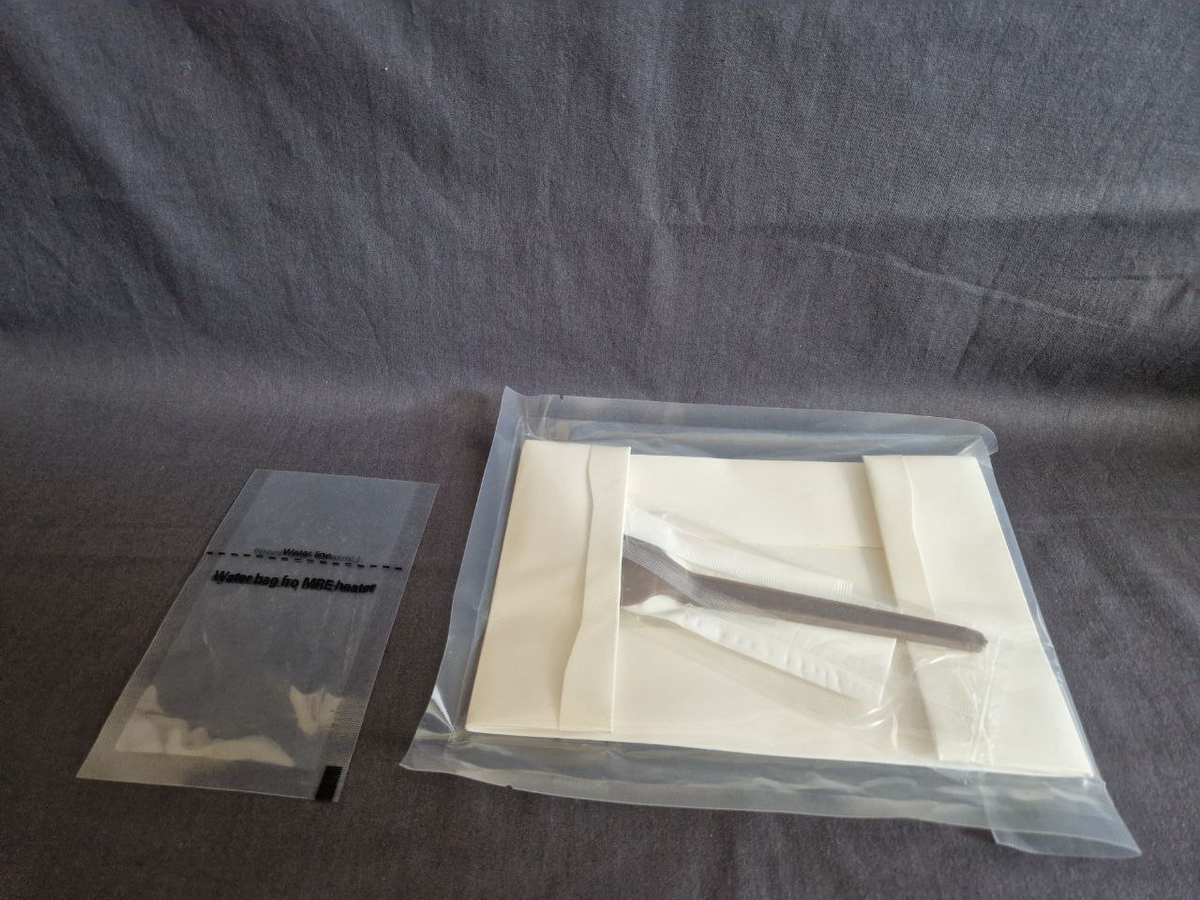 Бумажная "тарелка" со столовым прибором, мерный "стаканчик", предназначенный для залива воды к химическому реагенту