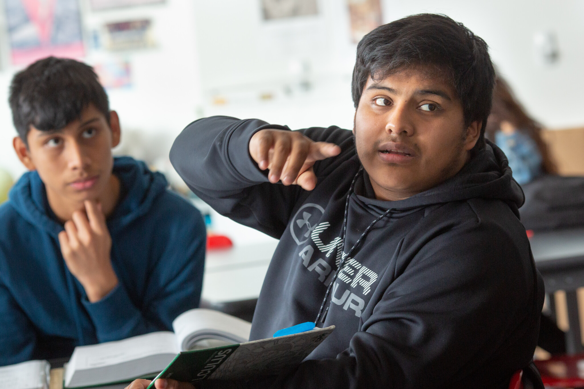 Ученик старшей школы задает вопрос на уроке математики.