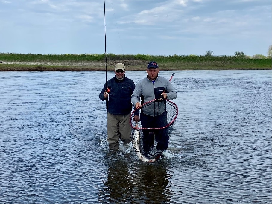 Рыба в подсаке. Идут отцеплять её на берегу.