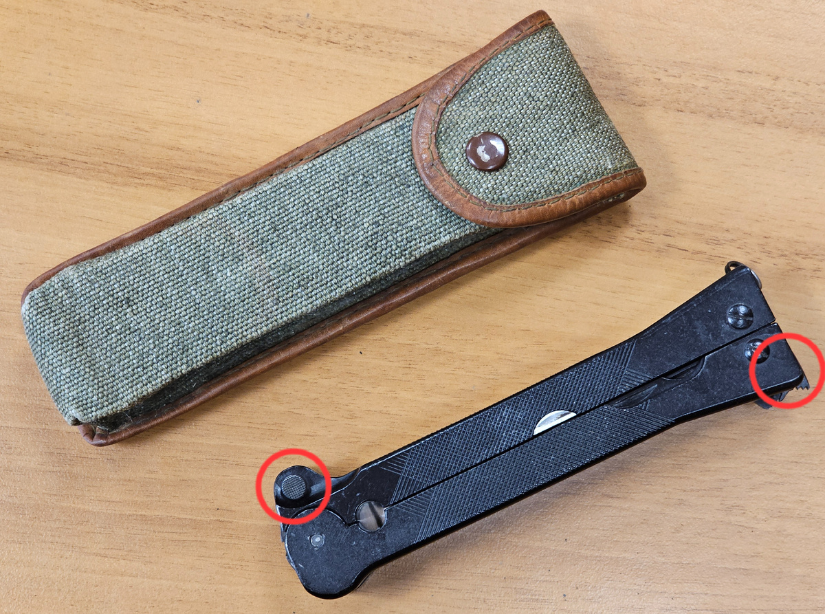 Нож Wz.69 в сложеном виде рядом со штатным чехлом. В красном кружке слева - кнопка выкидывания клинка, справа - защёлка фиксации половинок рукояти ножа.