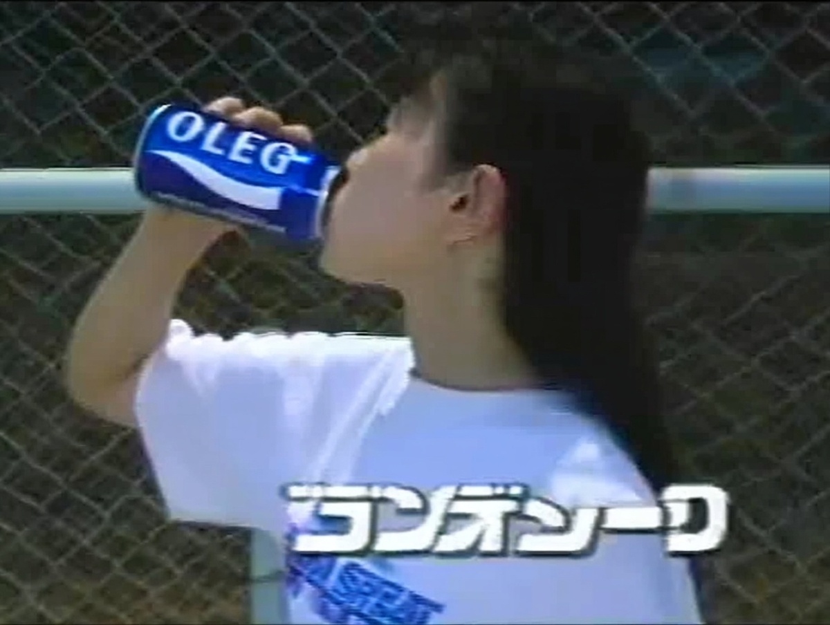 Девушка пьёт из банки напитка OLEG на спортивной площадке — возвращение культового бренда и его эстетики 80-х.