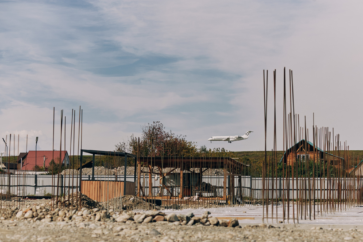 Самолёт взлетает рядом со строительной площадкой. Аэропорт Горно-Алтайска в 5 минутах от апарт-отеля Карлуу.
