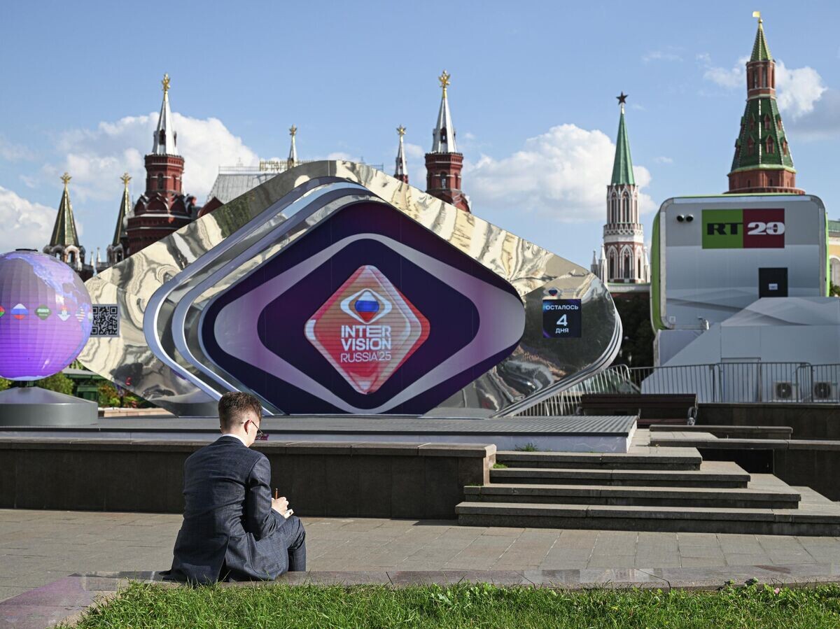    Мужчина перед сценой с символикой международного музыкального конкурса "Интервидение" на Манежной площади в Москве© РИА Новости / Кирилл Каллиников