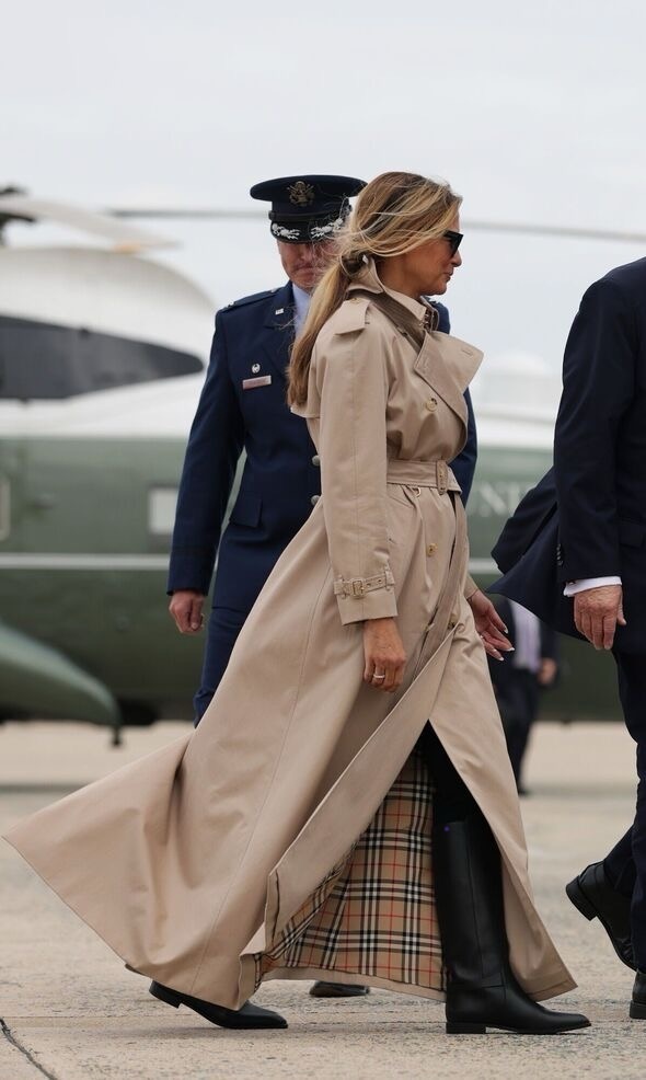 Мелания подготовилась к английской погоде (в плаще английской марки, сапогах чуть ли не резиновых). Сойдя с трапа вертолёта она как будто прямиком собралась покорять местные поля. Фотография из открытого источника. 