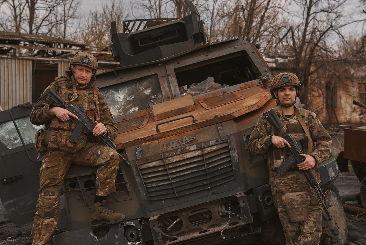Рядовые Александр Попов и Дмитрий Матушкин (справа) у сгоревшей бронемашины ВСУ «Козак».