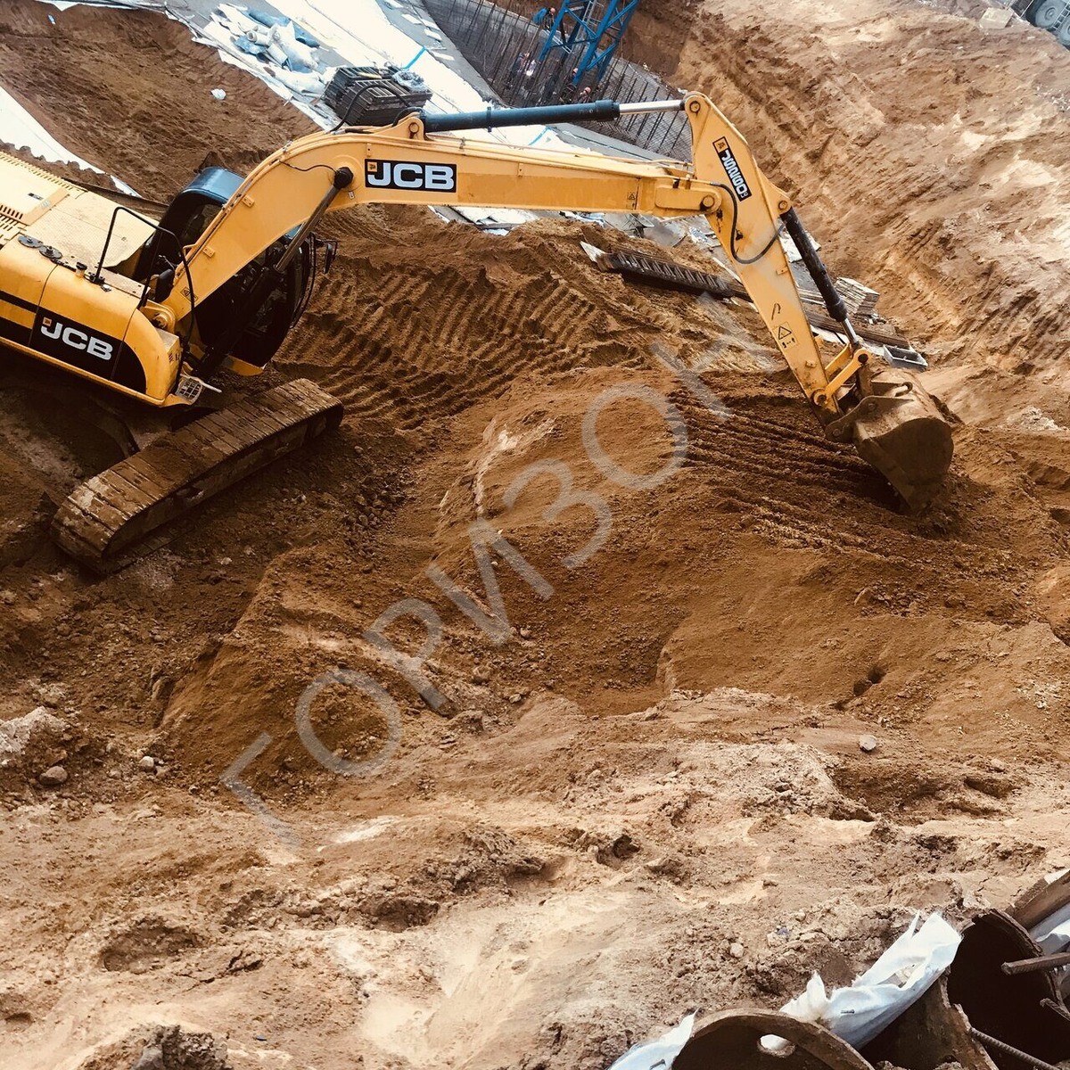 Ведется разработка грунта в котловане с погрузкой в самосвалы и вывозом на полигон