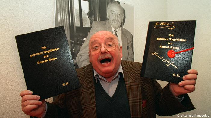 На фотографии — Конрад Куяу, автор той самой сенсации, известной как «дневники Гитлера». В руках он держит два тома с надписями на немецком: «Die geheimen Tagebücher des Konrad Kujau» («Секретные дневники Конрада Куяу»). На заднем плане — портрет того же Куяу. Источник: wtoutiao.com