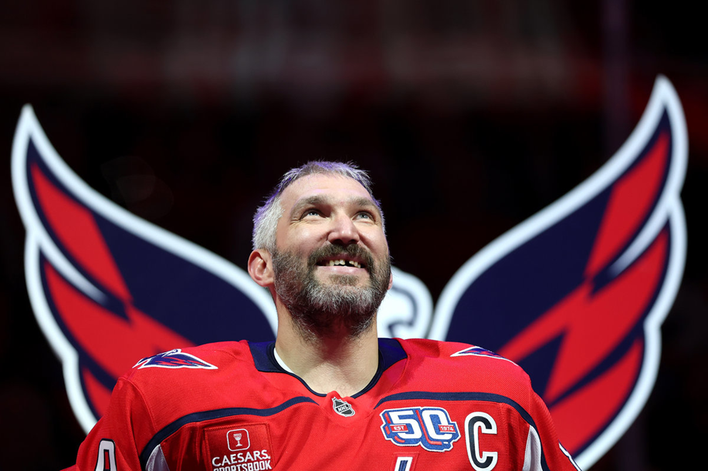 Капитан «Вашингтон Кэпиталз» в футболке команды с логотипом в виде крыльев на заднем плане