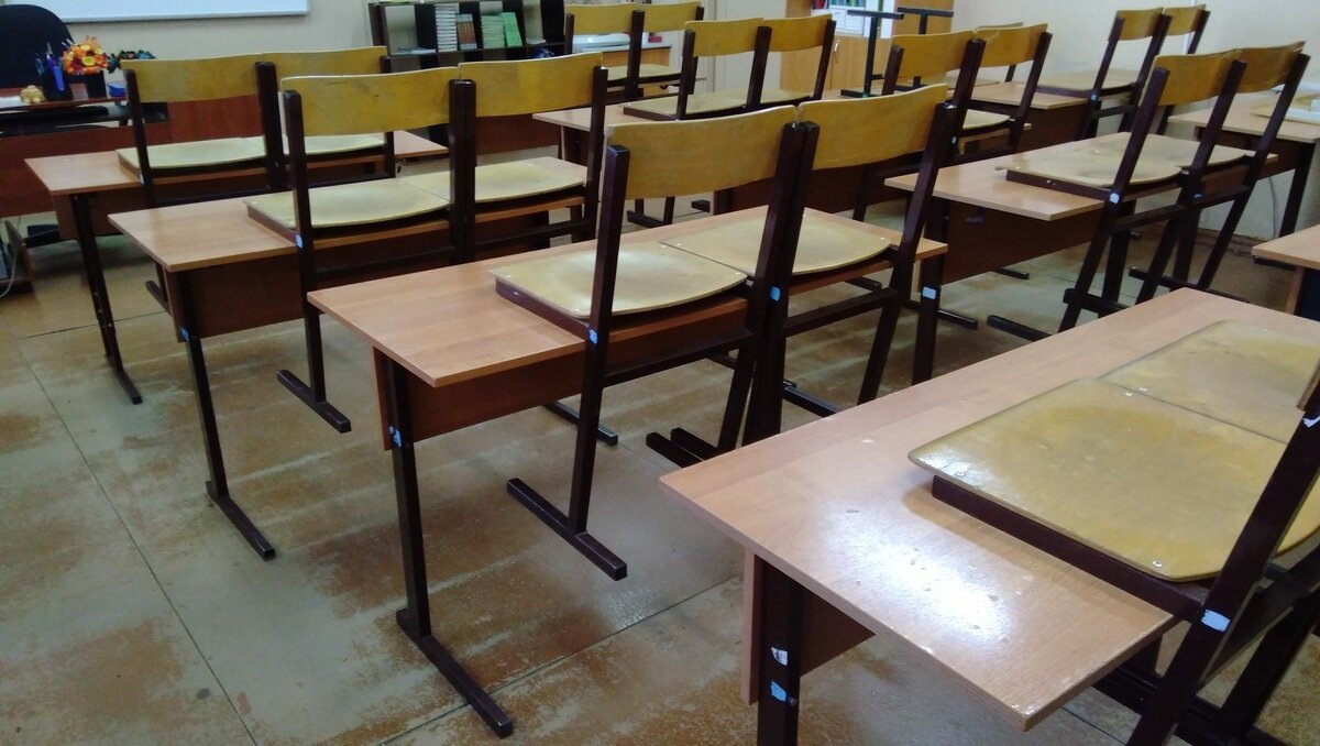 На этой фотографии один из классов в моей школе. Вечером зашёл в пустующий кабинет и сфоткал. Как видите, обычные столы и стулья с регулируемой высотой. И так во всех кабинетах.