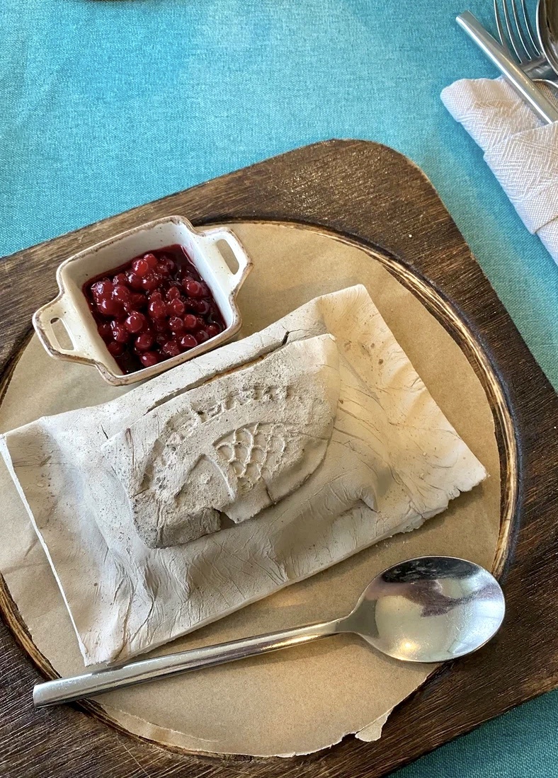 Рыба, запеченная в глине, так и подается - ложкой нужно разбить корочку, и развернуть пергаментный кармашек с форелью