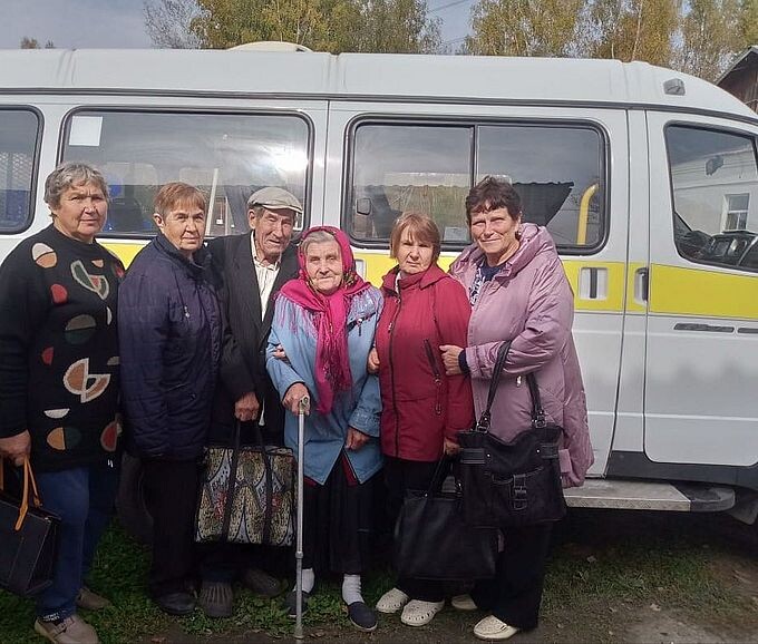Пожилые люди на фоне автомобиля мобильной бригады