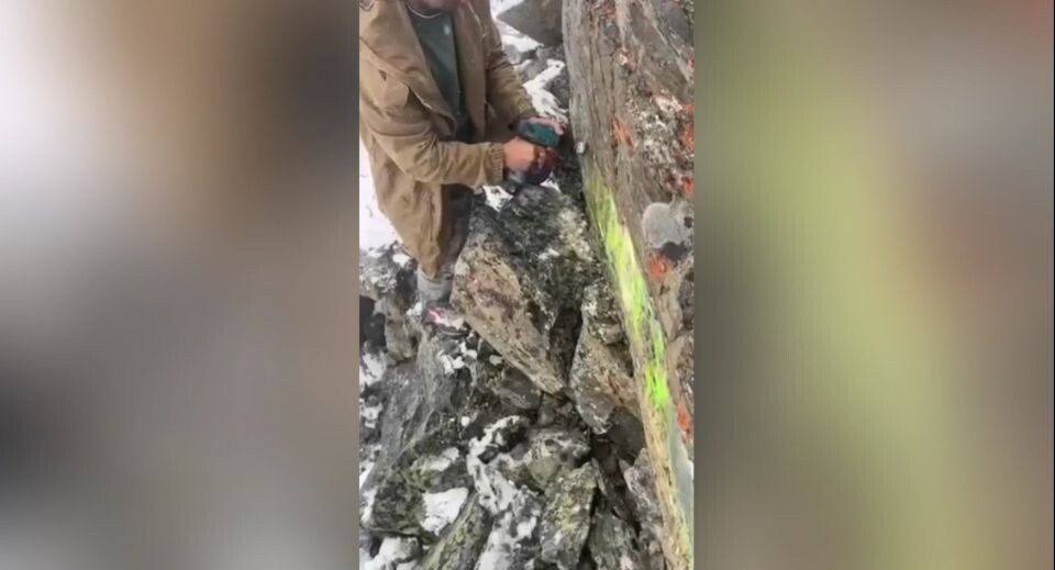    Турист убирает со скалы в Республике Алтай свою "живопись". Источник: Telegram-канал "Республика Алтай в Telegram"