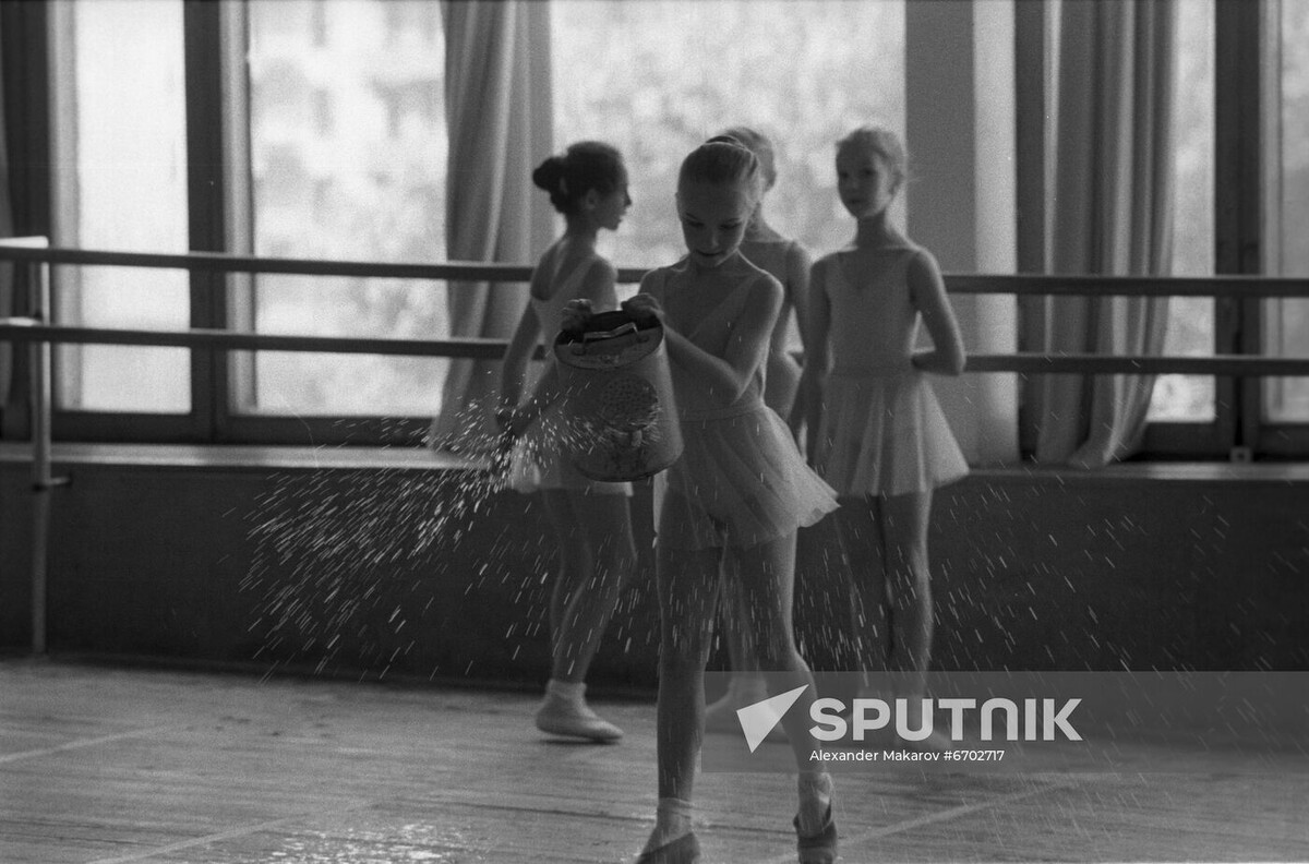 Дежурная девочка поливает пол в балетном зале