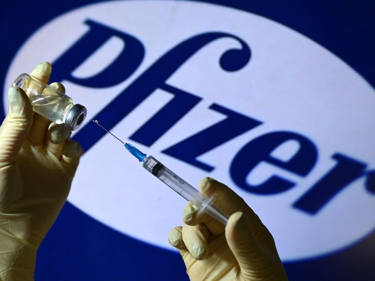    Шприц и ампула на фоне логотипа Pfizer© РИА Новости . Владимир Трефилов