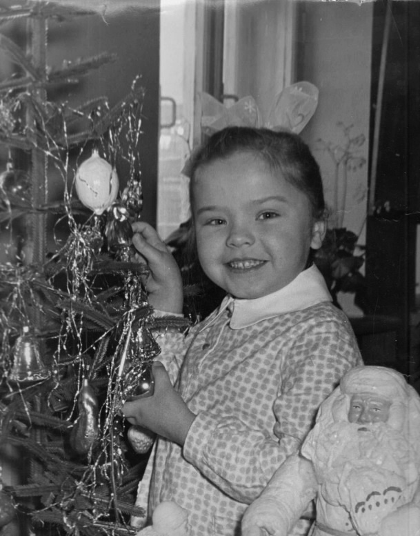 Детская фотография из СССР, где девочка наряжает елку - а папа фотографирует её