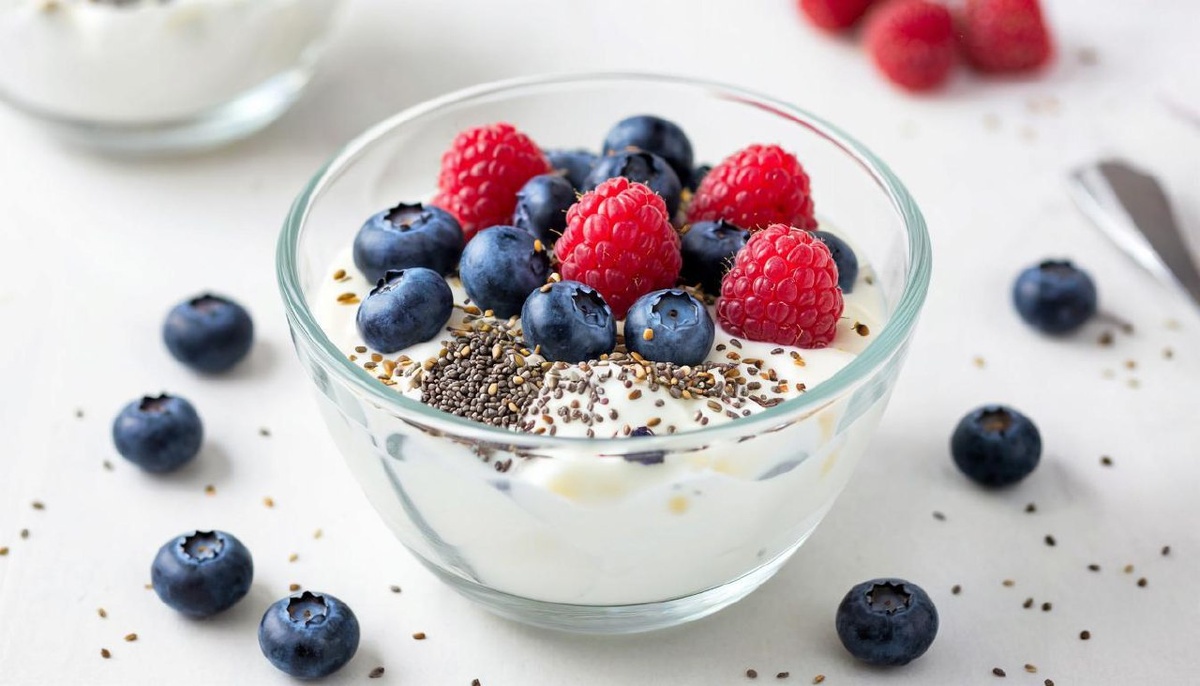 Прозрачная чаша с греческим йогуртом, свежей черникой, малиной и семенами чиа.