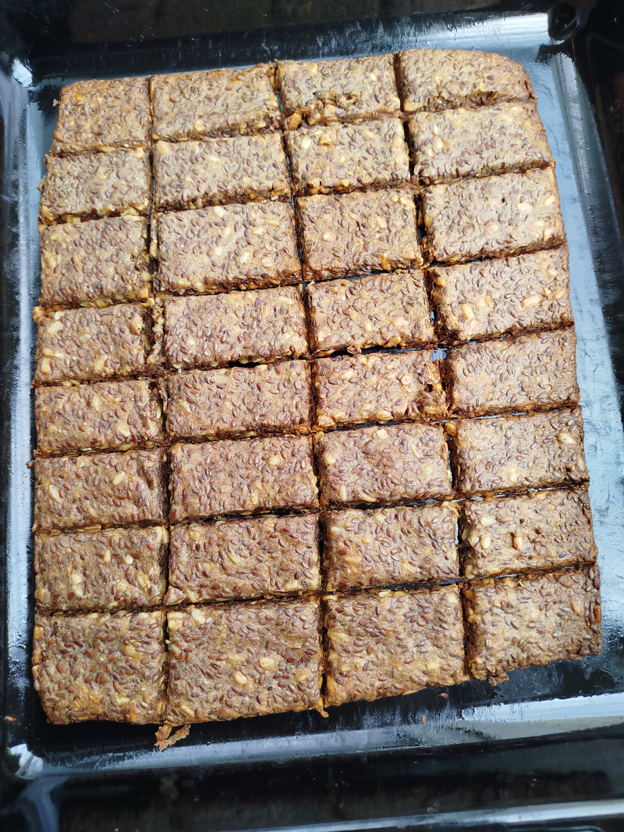 Семена льна залить водой. И оставить на полтора часа. Добавить
Затем добавить соль, пол стакана семечек ( подсолнечника, тмин, семена чиа). Растительное масло. Все перемешать. Постепенно высыпать стакан ржаной муки. Перемешать до однородного состояния. Получается густая липкая масса. Выложить на протвинь равномерно распределить толщину лопаткой. Толщина примерно 3 мм. Можно сверху ещё посыпать сухим кунжутом белым, для красоты. Пластиковым ножом ( предварительно его смазать растительным маслом) для теста разрезать пласт на мелкие кусочки.
Поставить протвинь в разогретую на 150 градусов духовку на 20 минут. Затем достать и повторно сделать надрезы.  СноваПоставить снова в духовку на 180 градусов на 35-40 минут.
Такие хлебцы можно подавать к первым блюдам, пить с чаем или молоком.