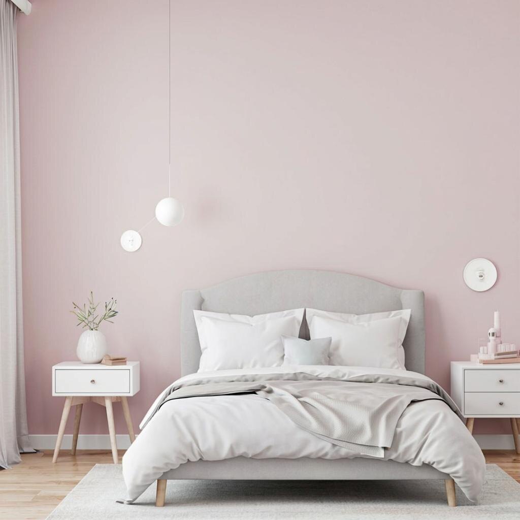 Спальня с пастельно-розовыми стенами, белой и светло-серой мебелью, уютной расслабляющей атмосферой в стиле минимализм.