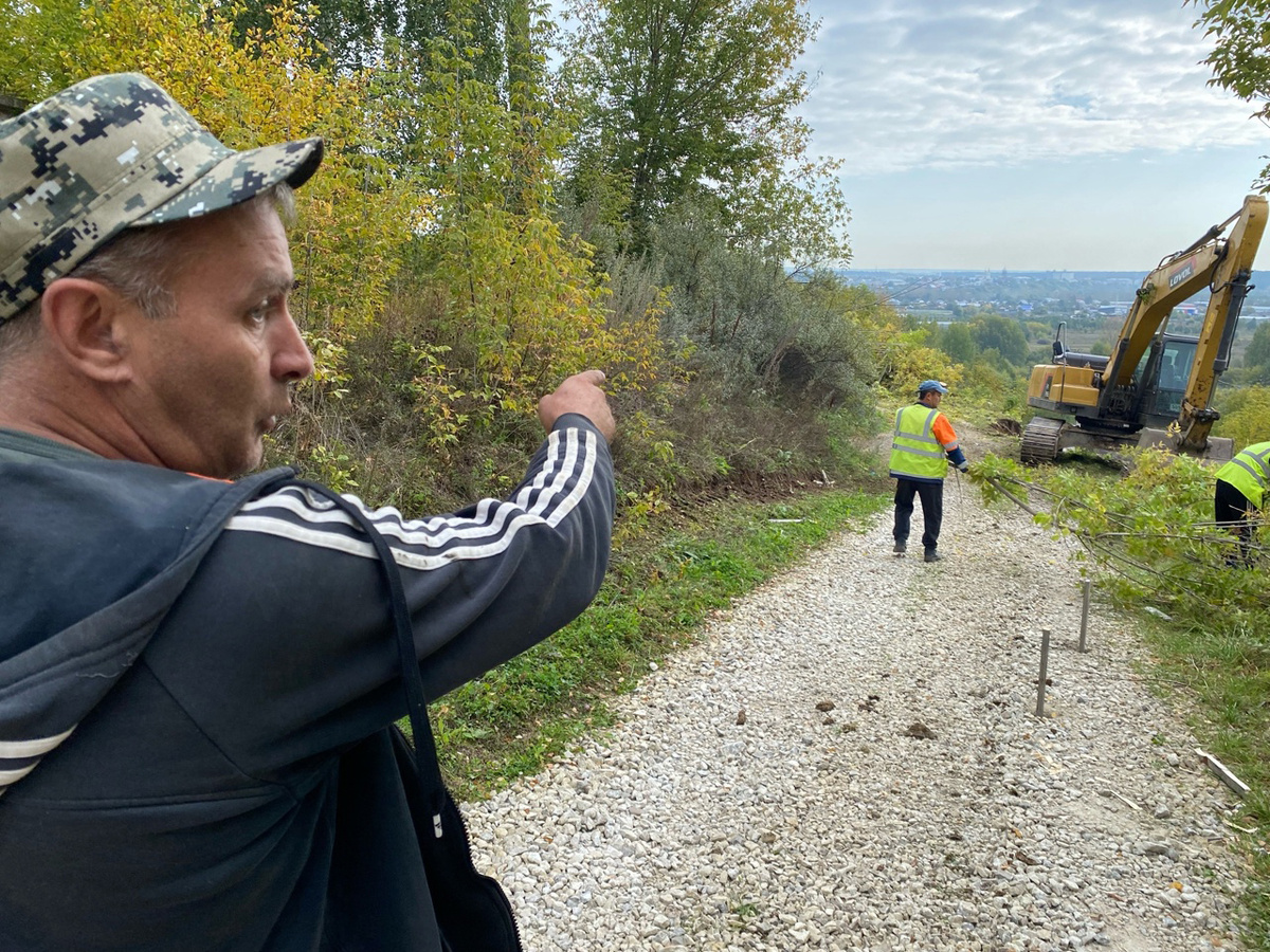 Александр Зубарев показывает границы будущего тротуара, а до него будут ступени