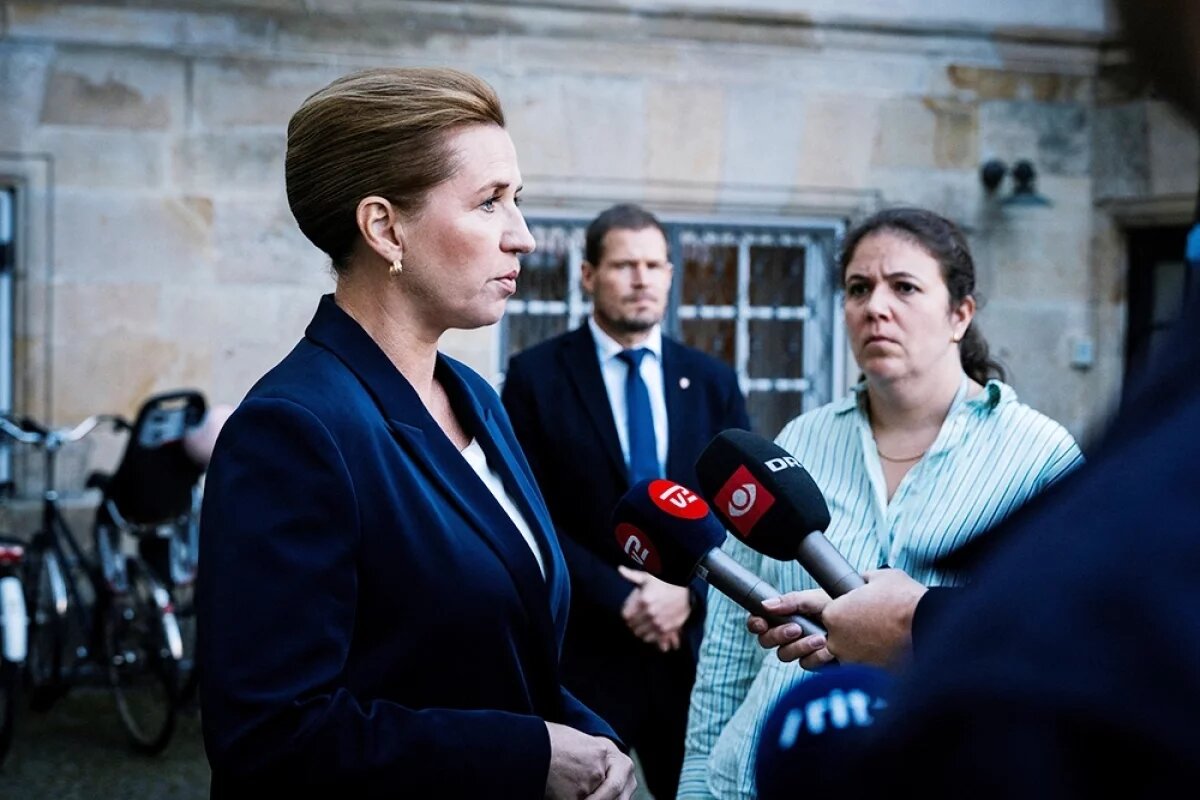    Премьер-министр Дании Метте Фредериксен стоит на пороге и комментирует активность беспилотников в понедельник вечером в аэропорту Копенгагена, Дания.